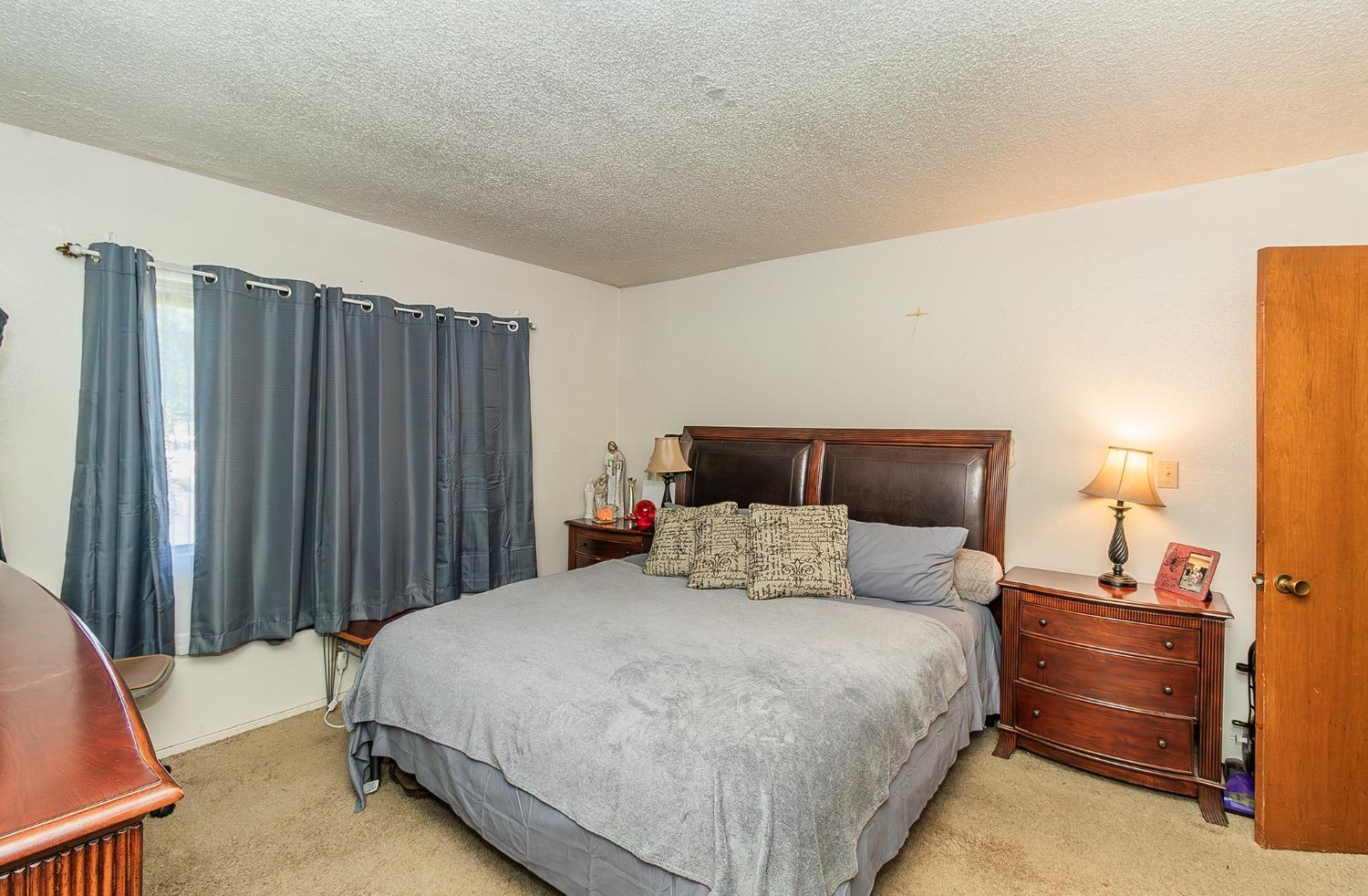 922 Music Avenue Clovis, CA 93612 - Photo 8 of 20 a bedroom with a bed and a night stand