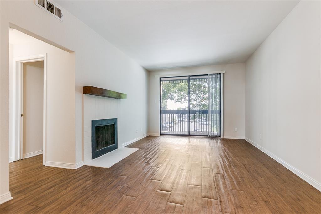 6122 Ridgecrest Road, Unit 2007 Dallas, TX 75231 - Photo 4 of 13 Unfurnished living room with a fireplace with flush hearth and wood finished floors