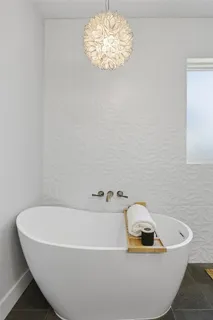 a bathroom with a tub and a chandelier