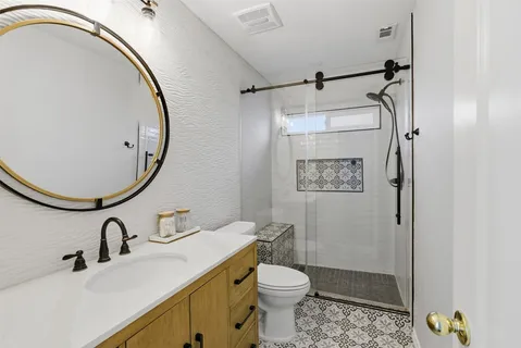 a bathroom with a sink mirror vanity and toilet