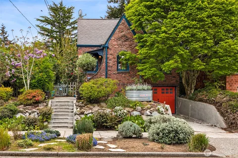 a front view of a house with a yard and potted plants