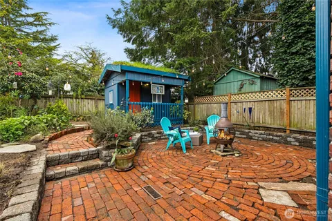 a view of a house with a small yard plants and a large tree