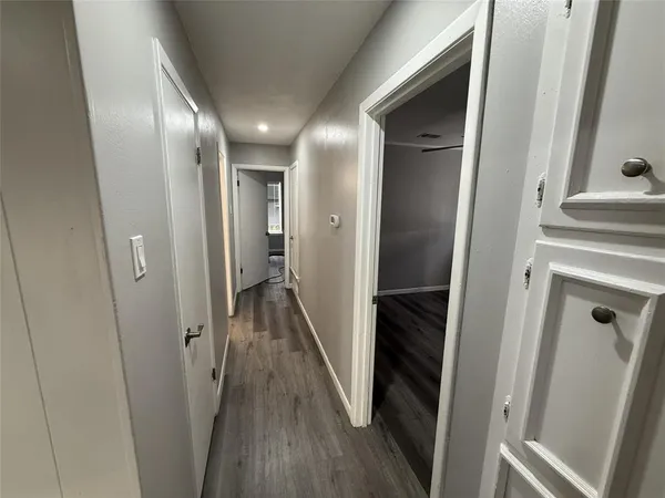 a view of a hallway with wooden floor and staircase