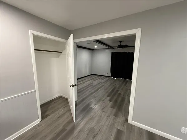 an empty room with wooden floor and closet