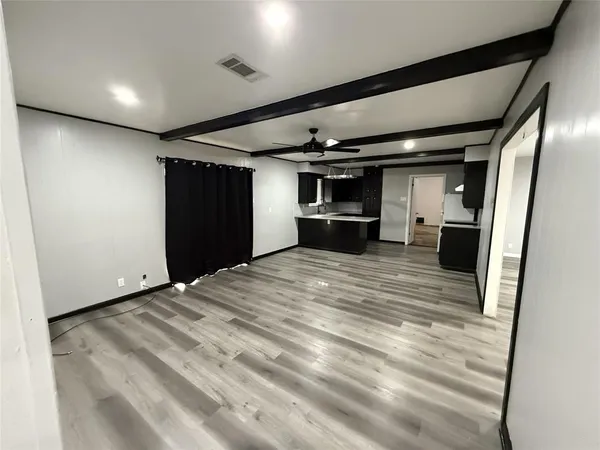 a view of empty room with wooden floor