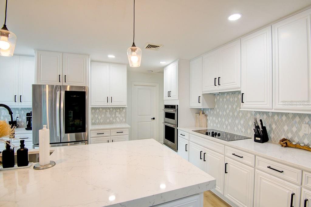 1720 Spring Creek Drive Sarasota, FL 34239 - Photo 12 of 63 a kitchen with stainless steel appliances a refrigerator sink and cabinets