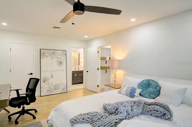 a bedroom with a bed and a flat tv screen on dresser