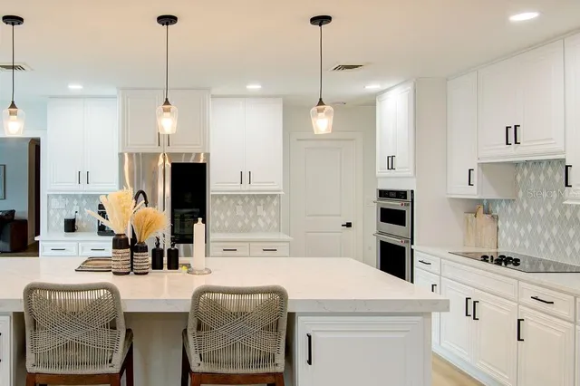 a kitchen with white cabinets and appliances
