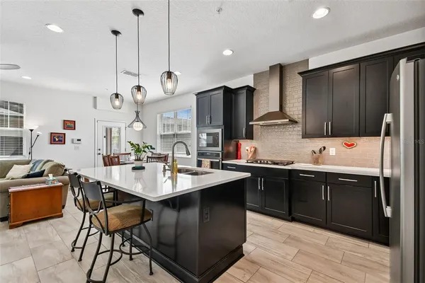 a kitchen with stainless steel appliances granite countertop a sink stove and refrigerator