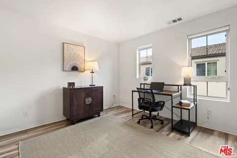 a view of a workspace with furniture and a window