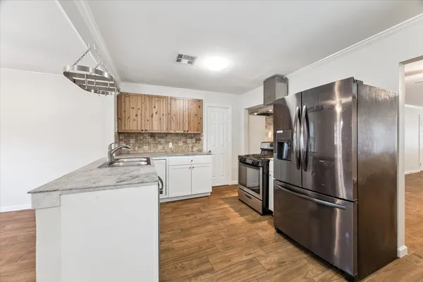 a kitchen with stainless steel appliances a refrigerator sink and cabinets