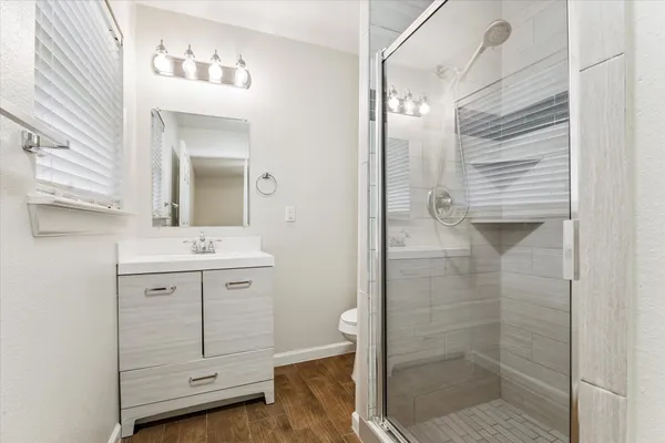 a bathroom with a shower sink and mirror