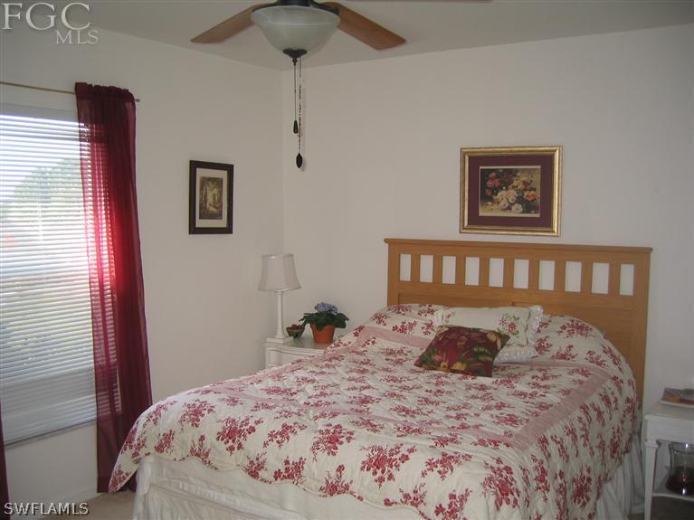 3618 20th Street Southwest Lehigh Acres, FL 33976 - Photo 9 of 12 a large bed sitting in a bedroom next to a window