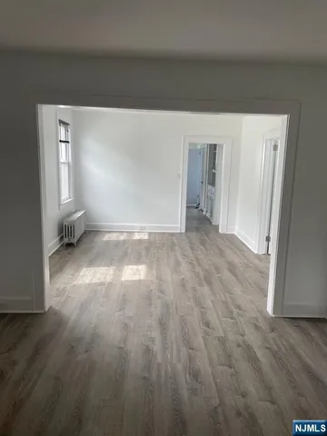 a view of a room with wooden floor and window