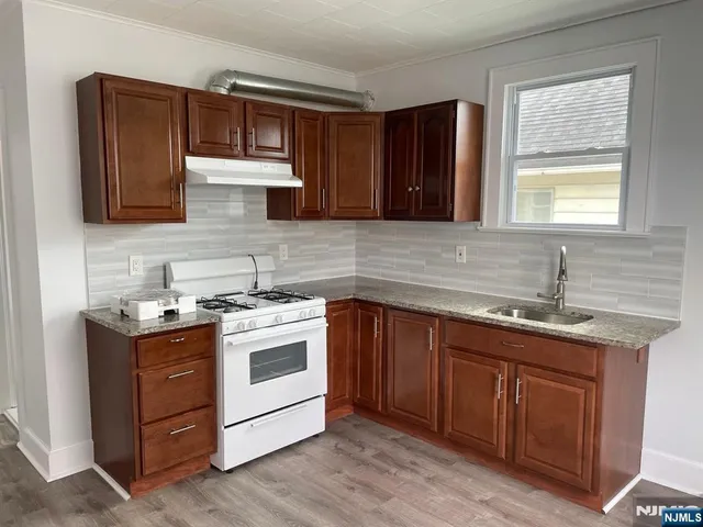 a kitchen with a stove sink and cabinets
