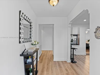 a view of a hallway with wooden floor and dining room