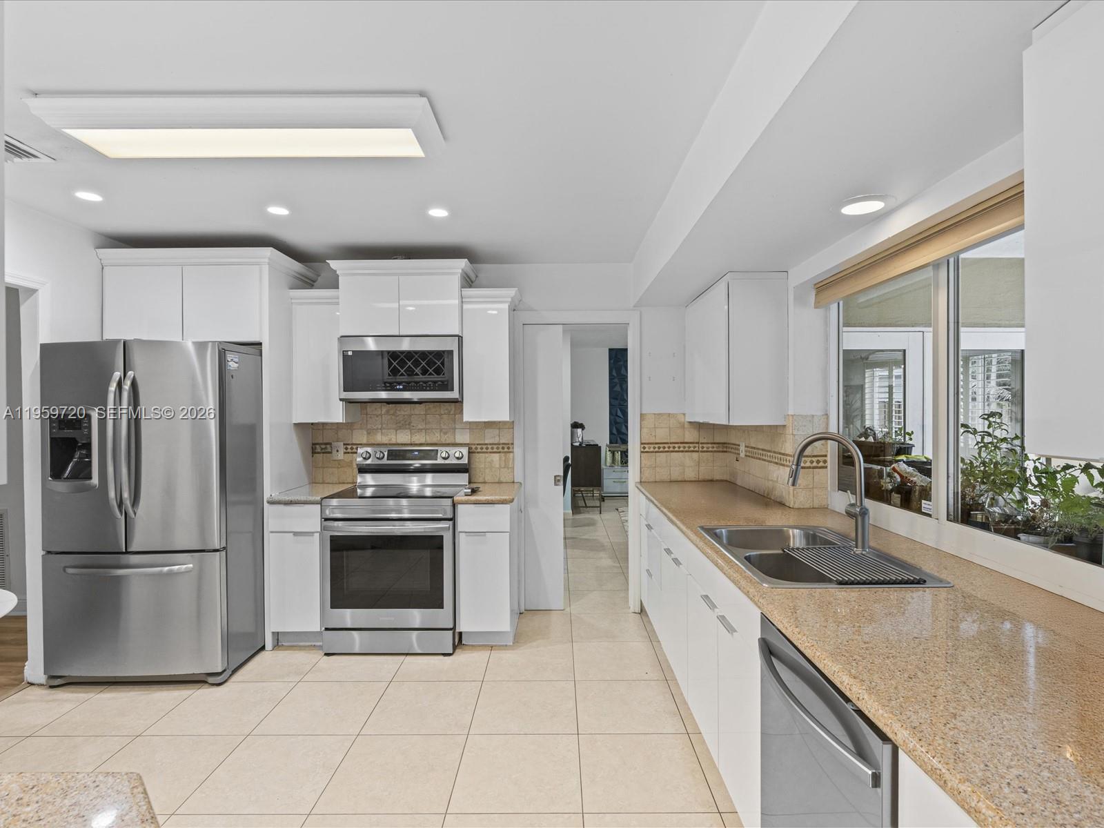 1113 North 46th Terrace Hollywood, FL 33021 - Photo 20 of 41 a kitchen with stainless steel appliances granite countertop a sink and a refrigerator