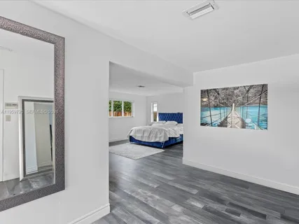 a bedroom with a bed and a painting on the wall