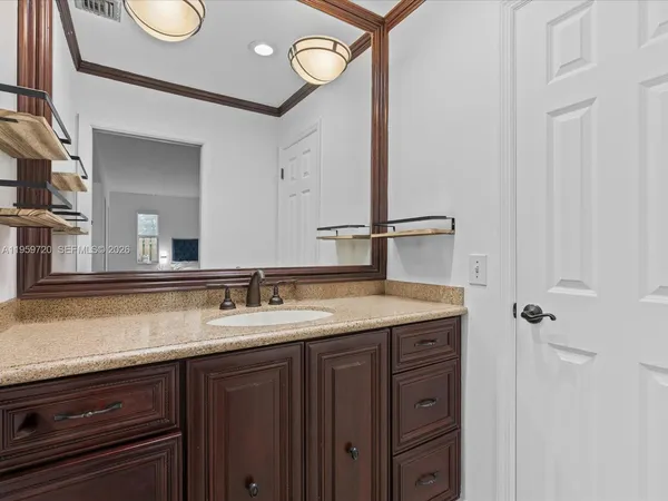 a bathroom with a granite countertop sink and a mirror