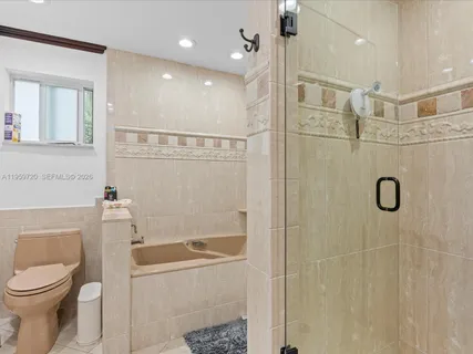 a bathroom with a toilet a sink a shower and mirror