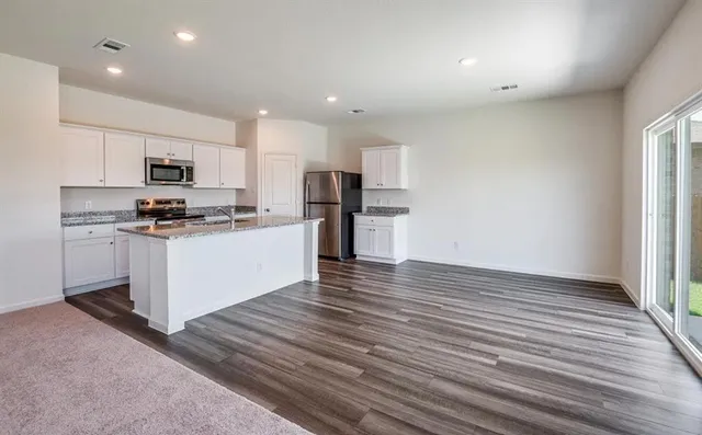 a kitchen with stainless steel appliances granite countertop a stove a sink and a refrigerator