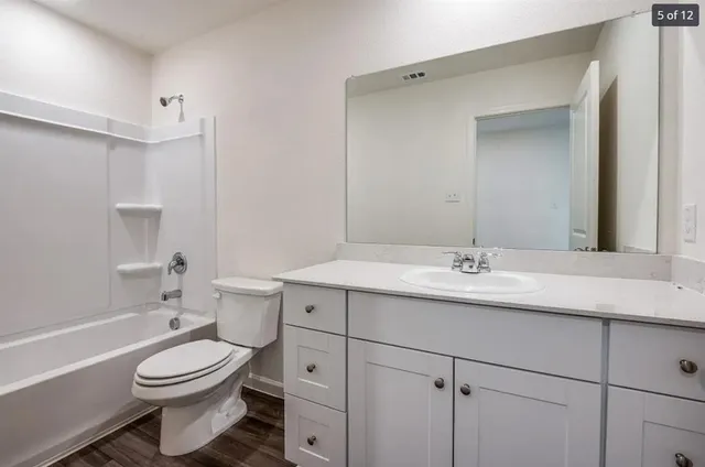 a bathroom with a granite countertop toilet sink and mirror