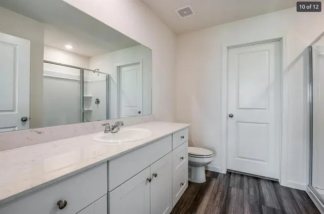 a bathroom with a sink a toilet a shower and a mirror