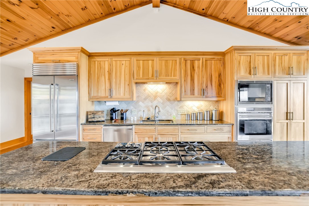324 Rocky Ridge Lane Glade Valley, NC 28627 - Photo 20 of 43 a kitchen with granite countertop a stove and white cabinets
