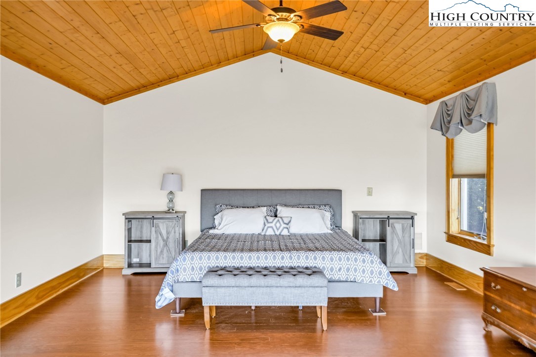 324 Rocky Ridge Lane Glade Valley, NC 28627 - Photo 29 of 43 a bedroom with a bed and wooden floor