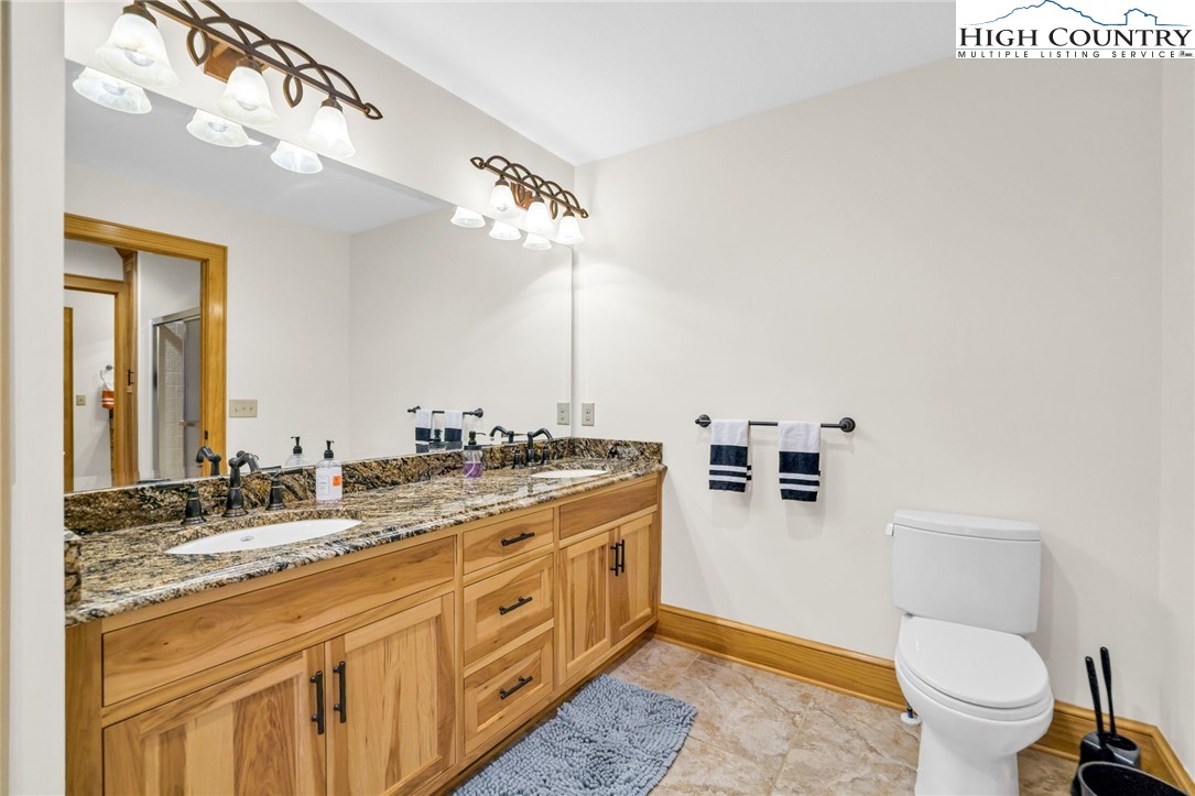 324 Rocky Ridge Lane Glade Valley, NC 28627 - Photo 33 of 43 a spacious bathroom with a granite countertop toilet sink and mirror