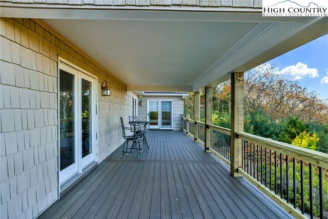 a view of a balcony with chairs and wooden floor