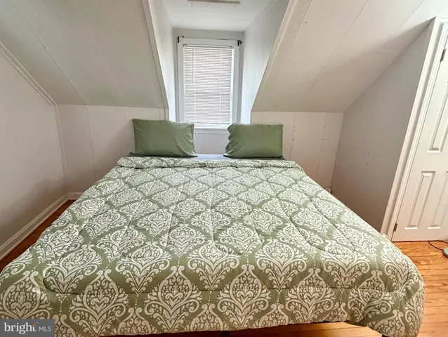 a large bed sitting in a bedroom next to a window
