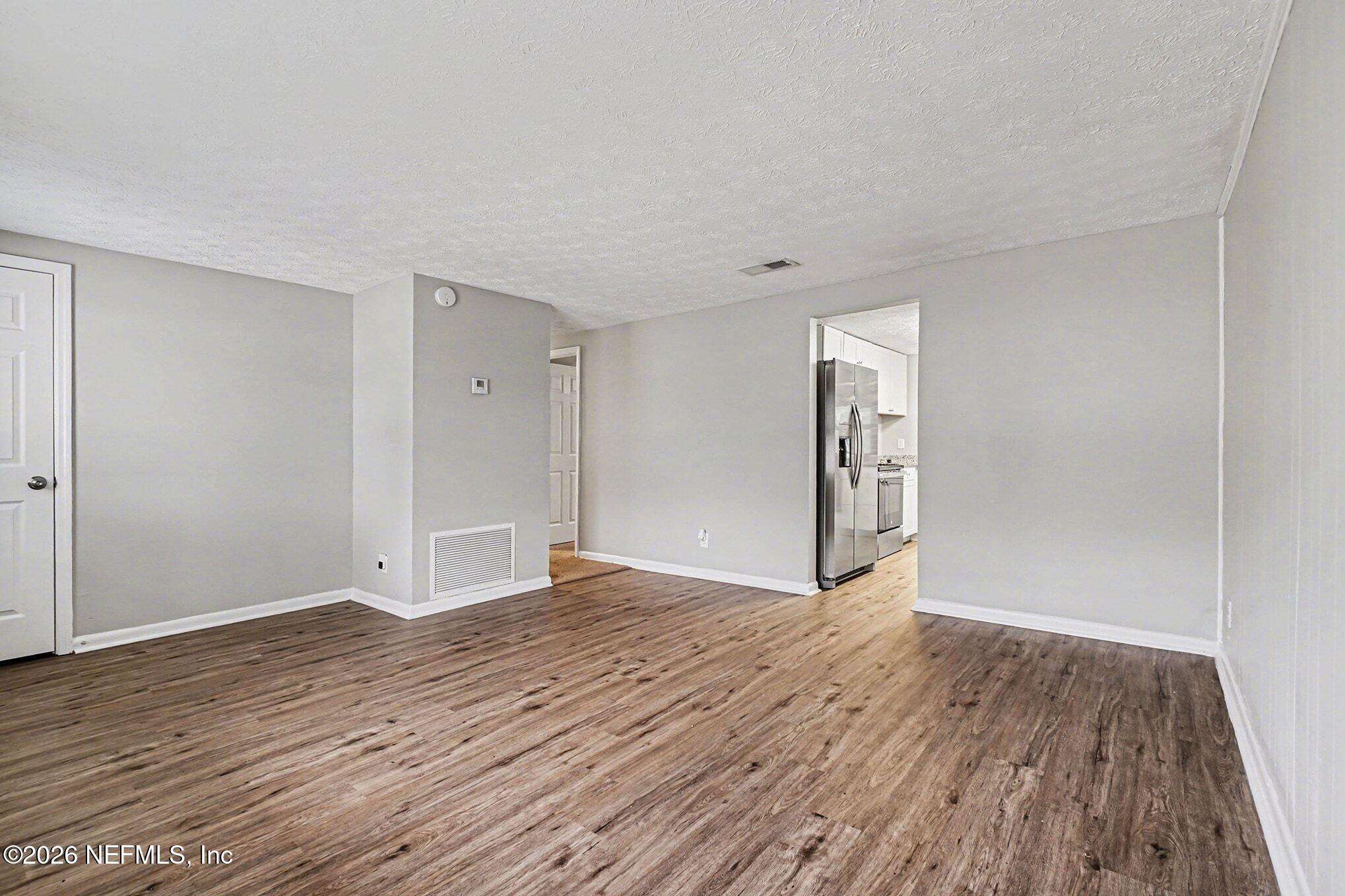 8417 Barracuda Road Jacksonville, FL 32244 - Photo 4 of 15 a view of an empty room with wooden floor