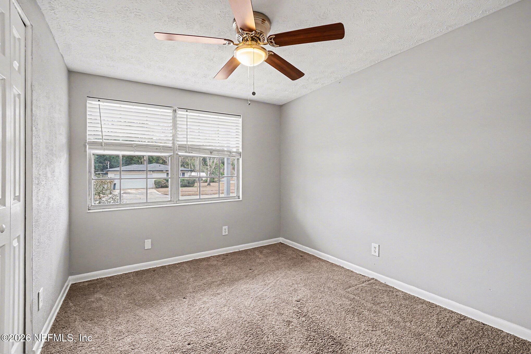 8417 Barracuda Road Jacksonville, FL 32244 - Photo 9 of 15 an empty room with a window and a fan