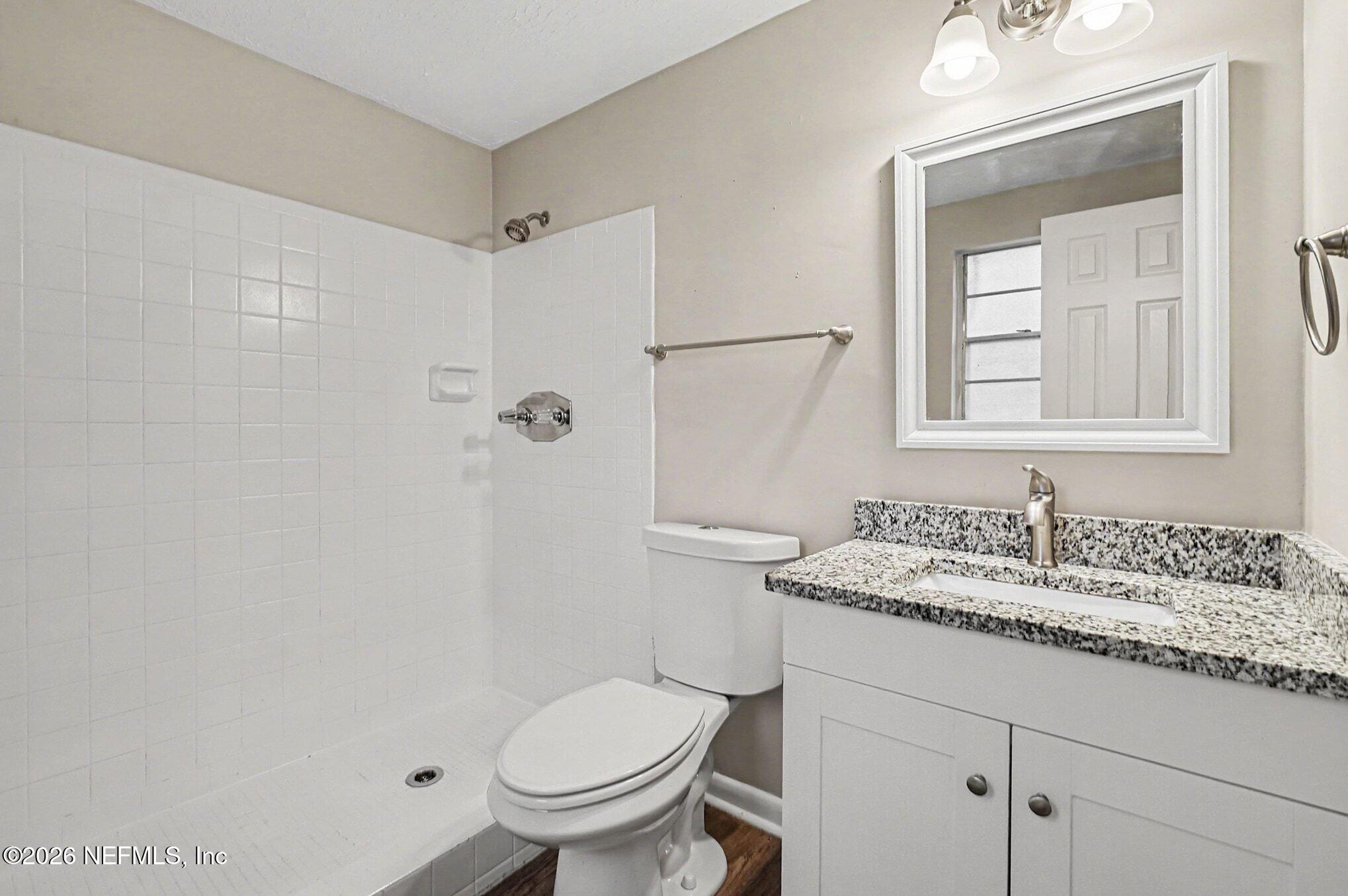 8417 Barracuda Road Jacksonville, FL 32244 - Photo 10 of 15 a bathroom with a granite countertop sink toilet and mirror