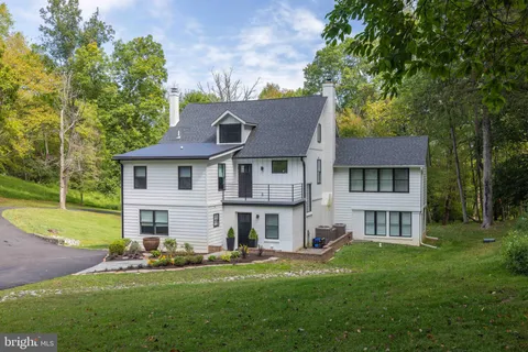 a front view of a house with a garden and trees