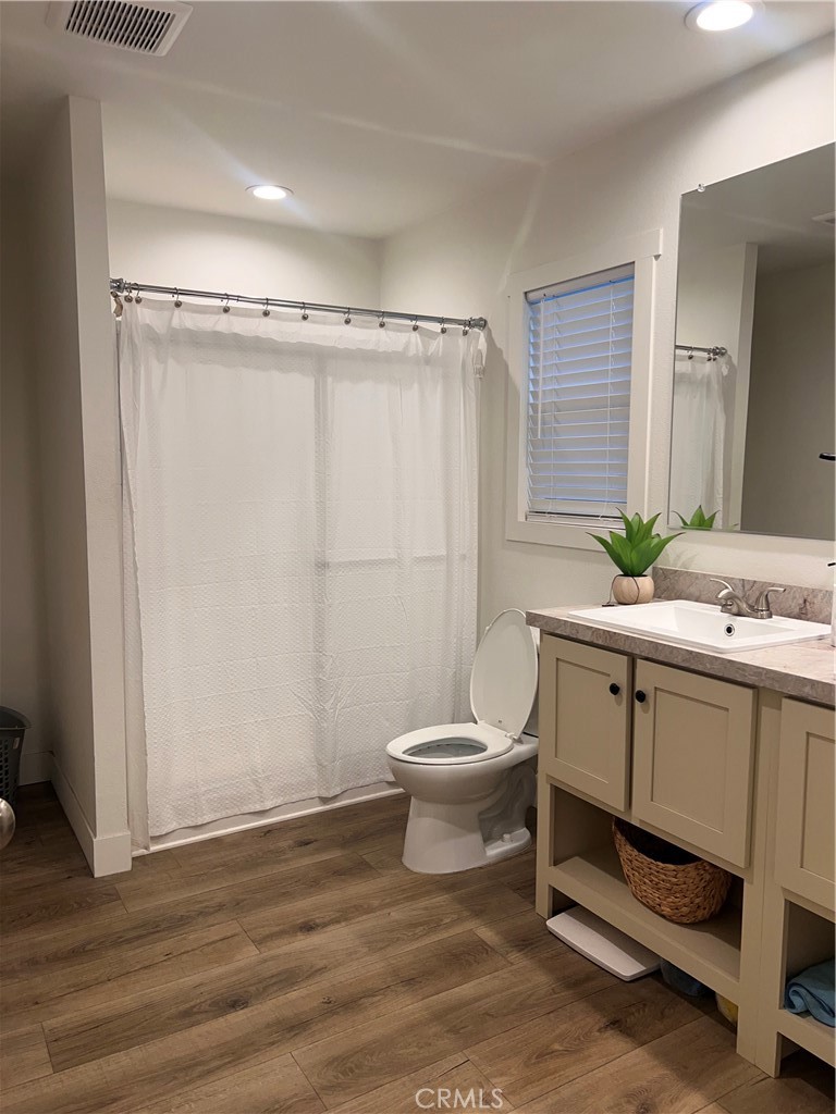 3444 West Center Street, Unit 43 Riverside, CA 92501 - Photo 12 of 16 a bathroom with a white toilet sitting next to a bathroom sink and a granite counter