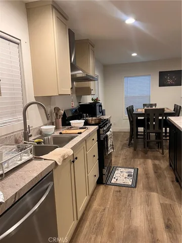 a kitchen with a sink a stove cabinets and wooden floor