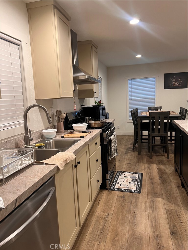 3444 West Center Street, Unit 43 Riverside, CA 92501 - Photo 5 of 16 a kitchen with a sink a stove cabinets and wooden floor
