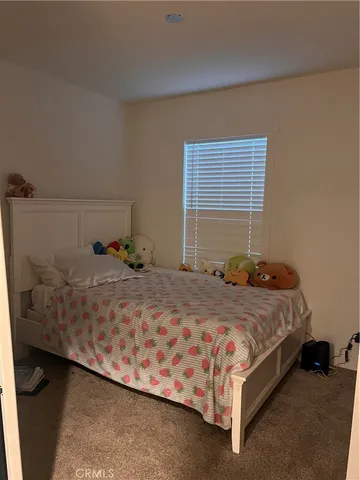 a bed sitting in a bedroom next to a window