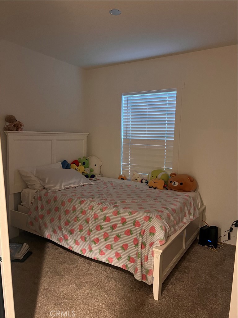 3444 West Center Street, Unit 43 Riverside, CA 92501 - Photo 8 of 16 a bed sitting in a bedroom next to a window