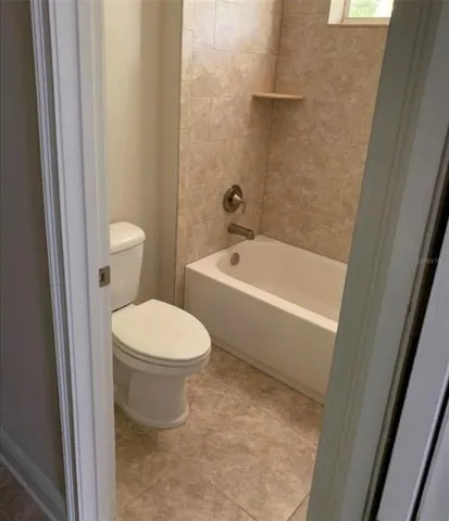a white toilet sitting next to a bath tub