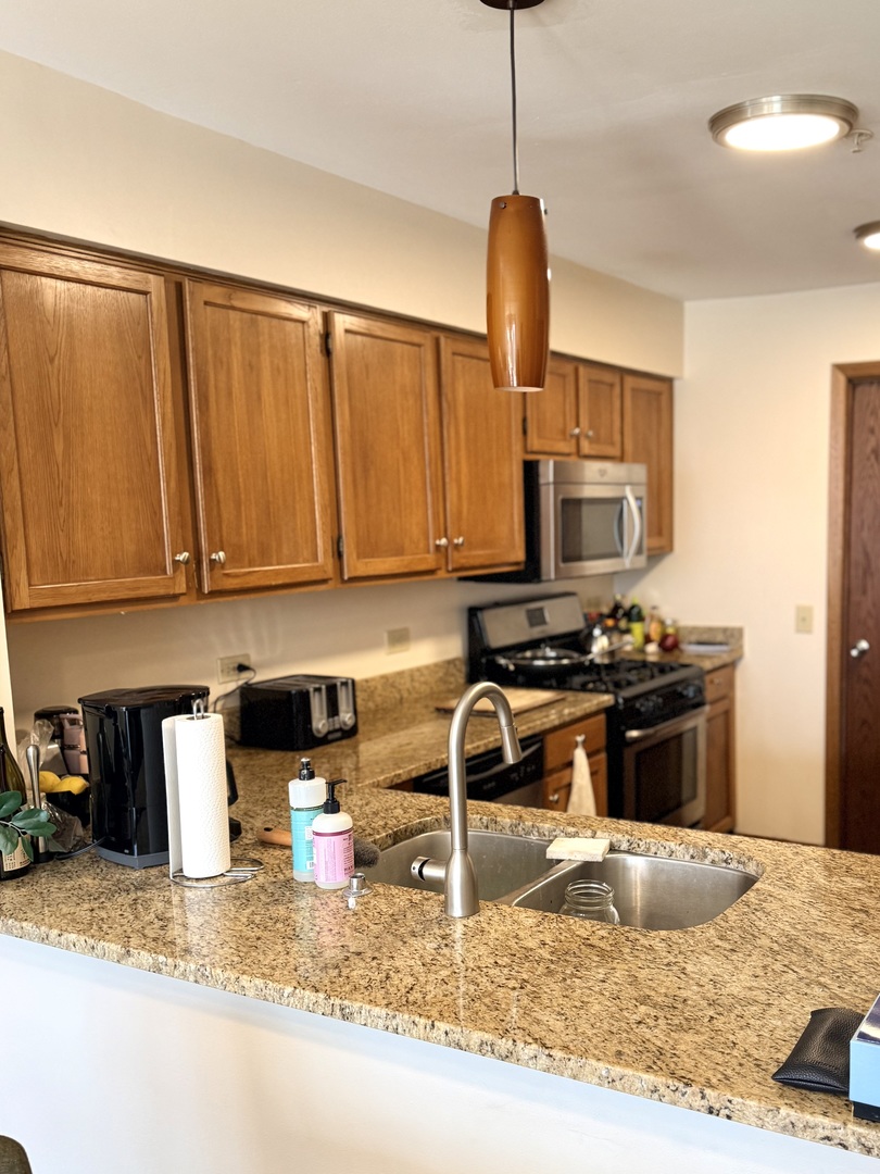 1159 East Addison Avenue Lombard, IL 60148 - Photo 4 of 14 a kitchen with a stove a sink and a microwave