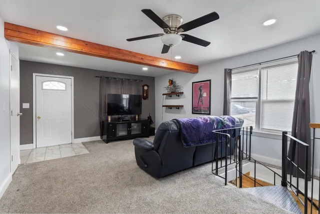 a living room with furniture a window and a flat screen tv