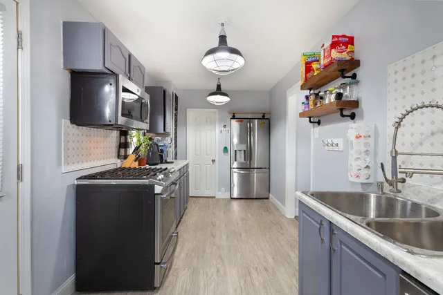 a kitchen with stainless steel appliances granite countertop a sink stove and refrigerator