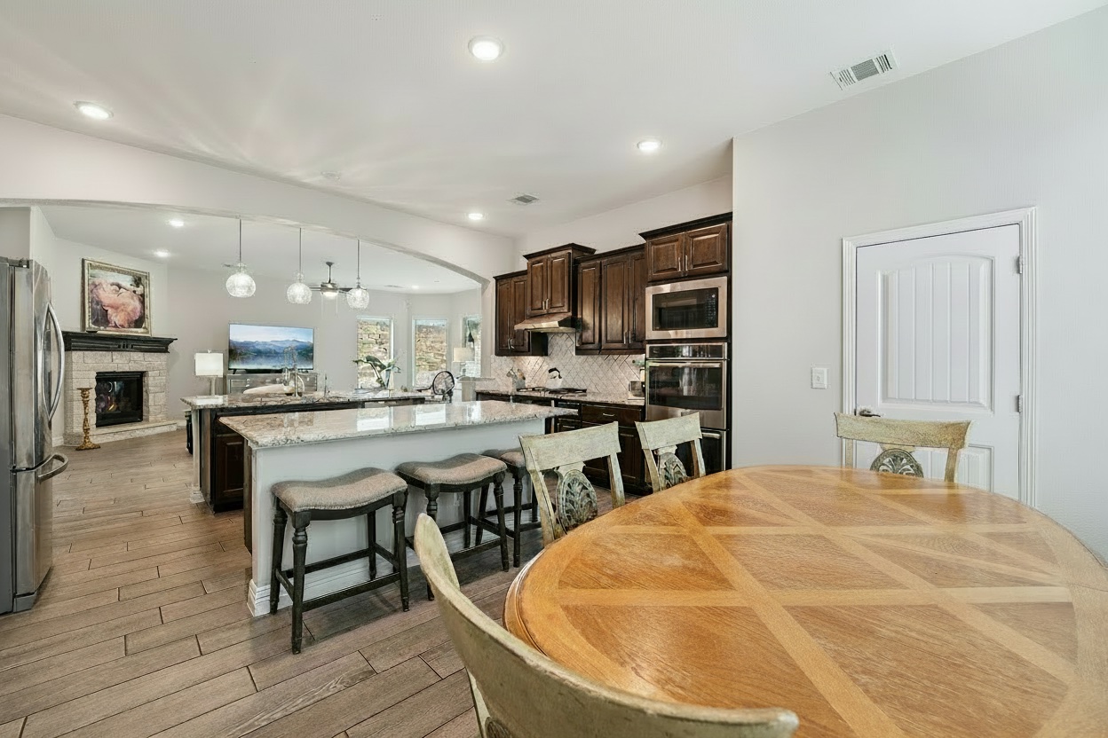 17820 Limestone Spring Lane Austin, TX 78738 - Photo 14 of 35 a room with stainless steel appliances kitchen island granite countertop a stove a sink a dining table and chairs