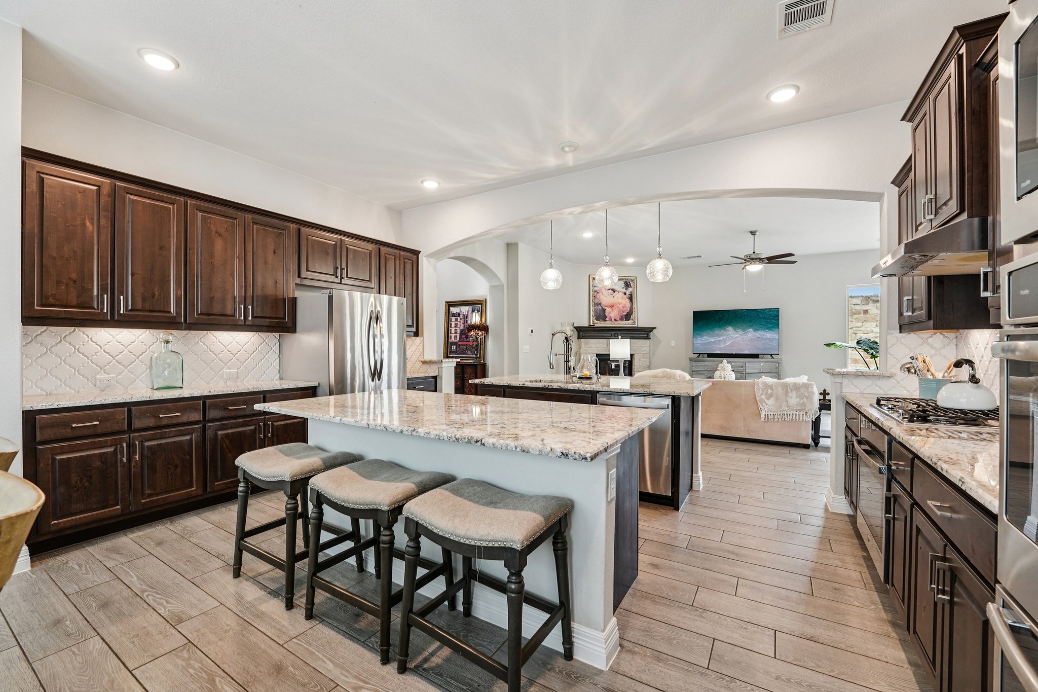 17820 Limestone Spring Lane Austin, TX 78738 - Photo 9 of 35 a kitchen with stainless steel appliances granite countertop table chairs sink and cabinets
