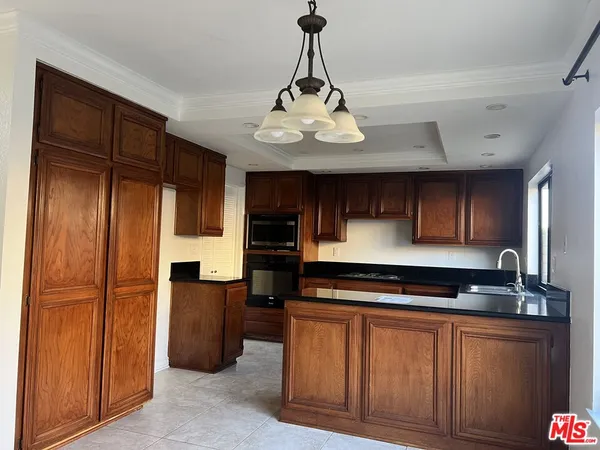 a large kitchen with stainless steel appliances granite countertop a stove and a refrigerator