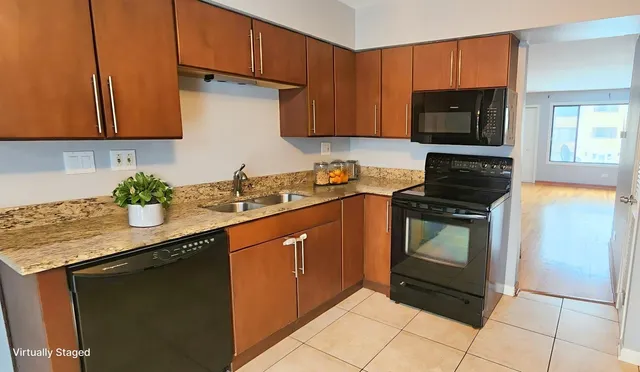 a kitchen with stainless steel appliances granite countertop a sink stove and microwave
