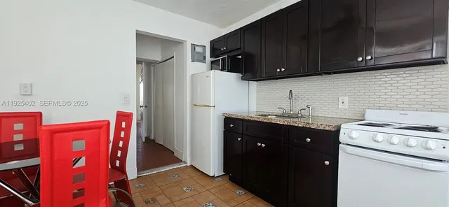 a kitchen with stainless steel appliances granite countertop a refrigerator and a stove